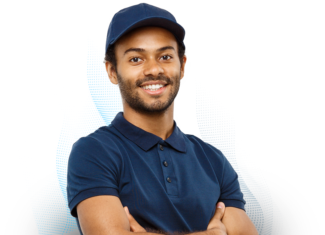 Homem negro com uma barba rala, sorrindo e com os braços cruzados, usando uma camisa e boné azuis